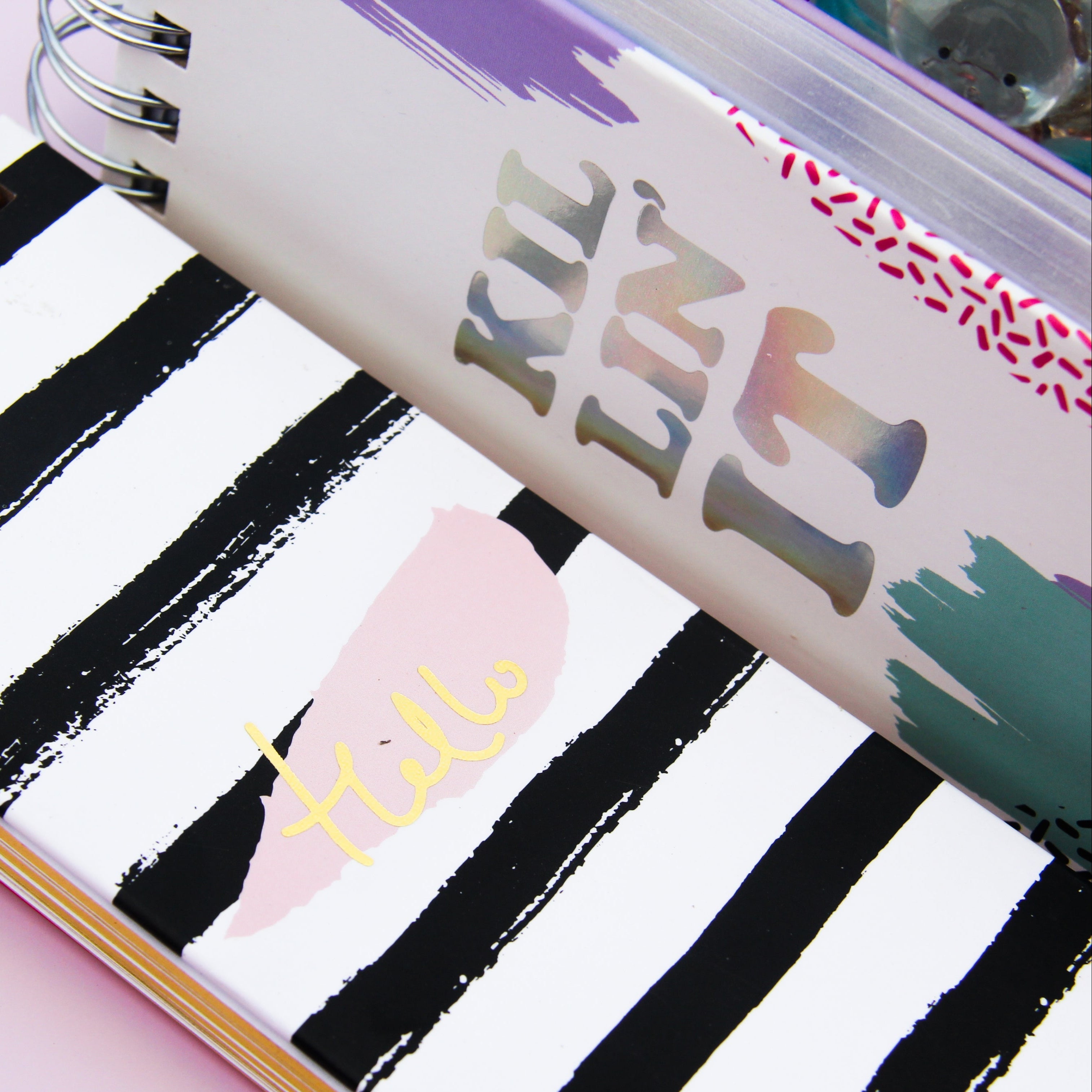 Notebook with black and white striped cover and 'Hello' text.