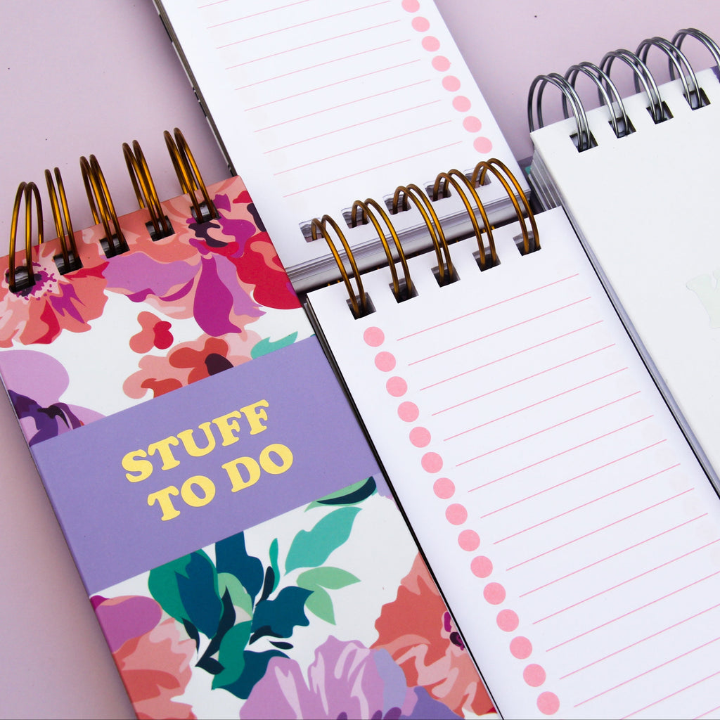 Notebook with floral cover and 'STUFF TO DO' text on a light purple background
